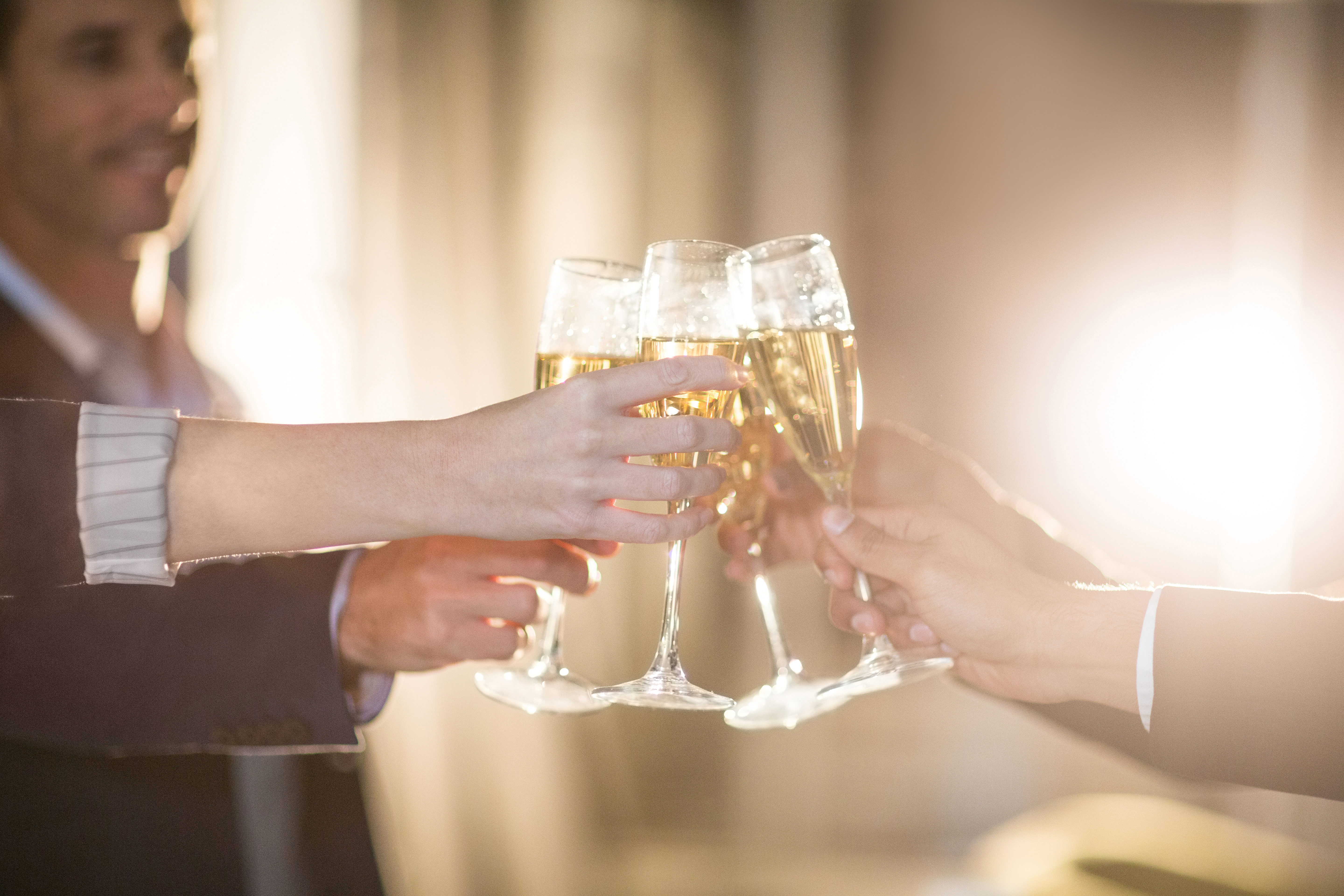 Close-up of group of businesspeople toasting glasses of champagne in t